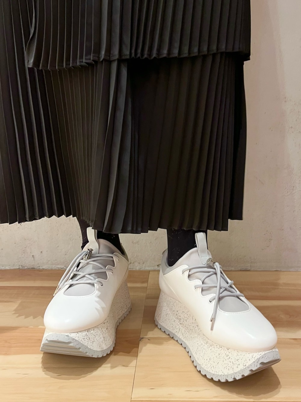 グレー系のワンピース、ホワイト系のスニーカー、ホワイト系のショルダーバッグを着用したレディースの冬コーディネートの8枚目の写真