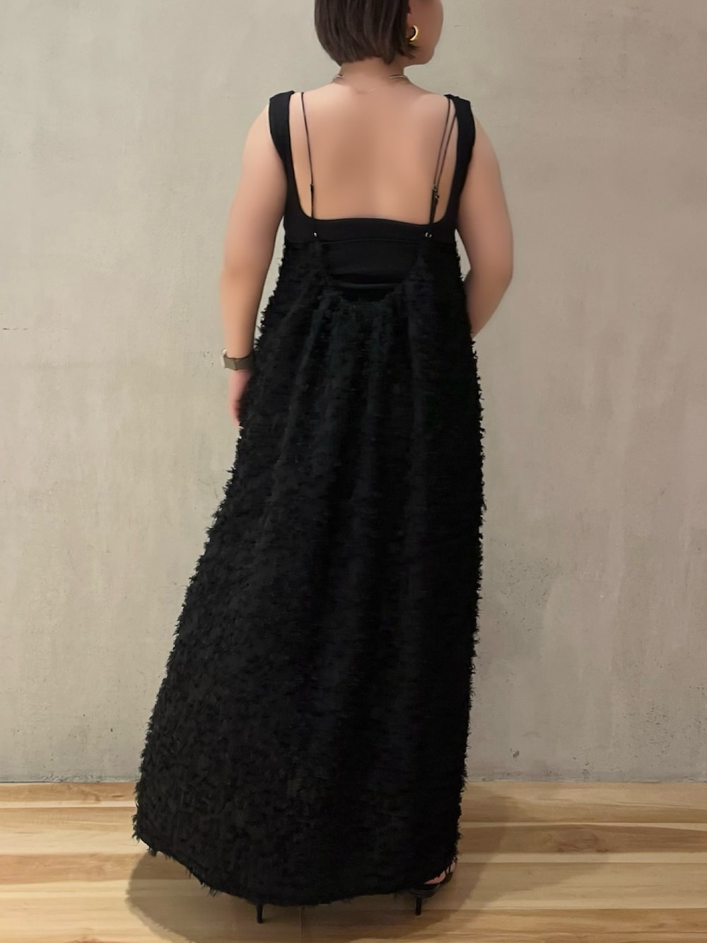 ブラック系のワンピース、ブラック系のタンクトップ、ベージュ系のノーカラーコートを着用したレディースの春コーディネートの7枚目の写真