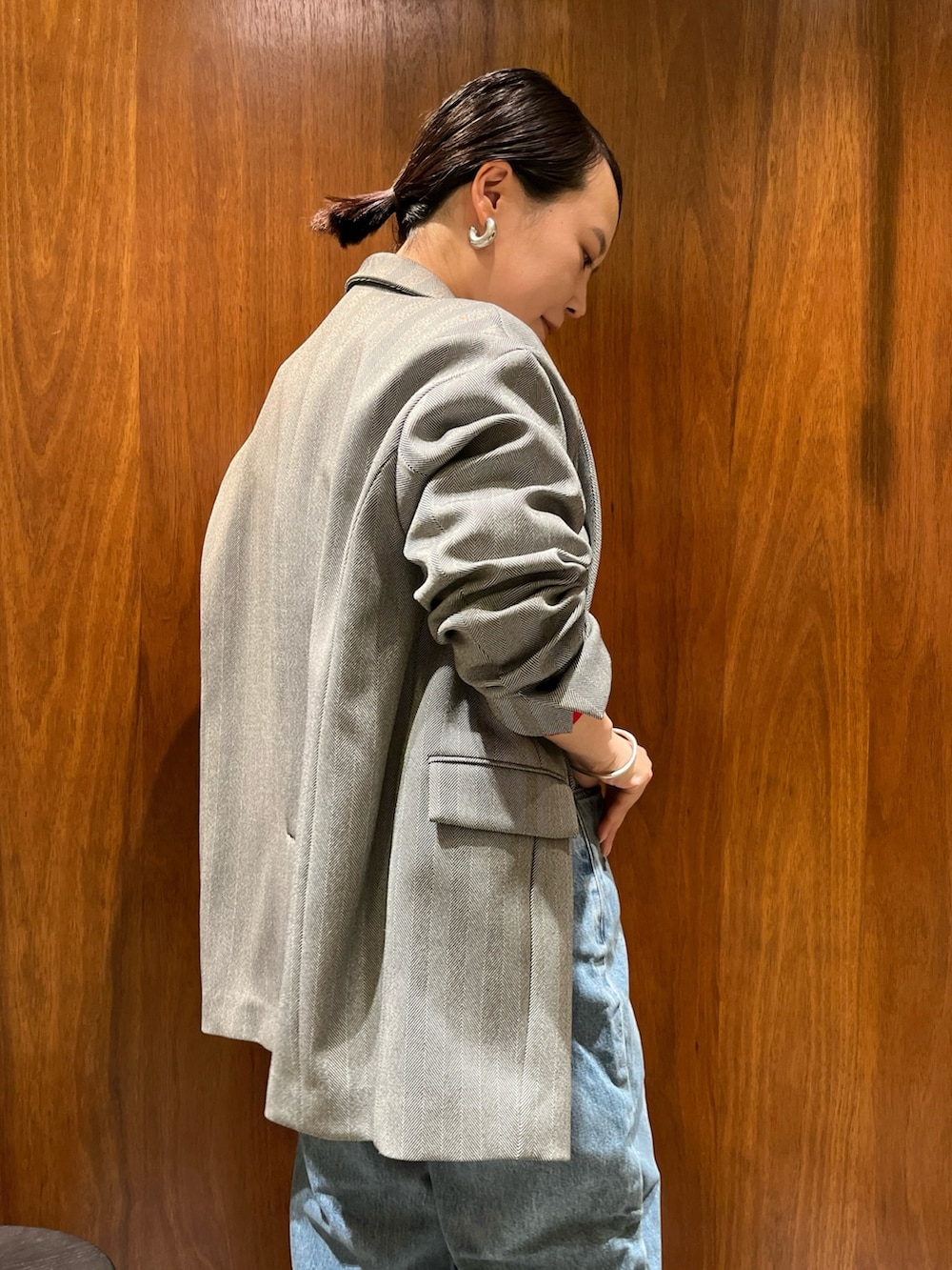 ブラック系のテーラードジャケット、レッド系のカーディガン/ボレロ、ブラック系のハンドバッグを着用したレディースの秋コーディネートの6枚目の写真