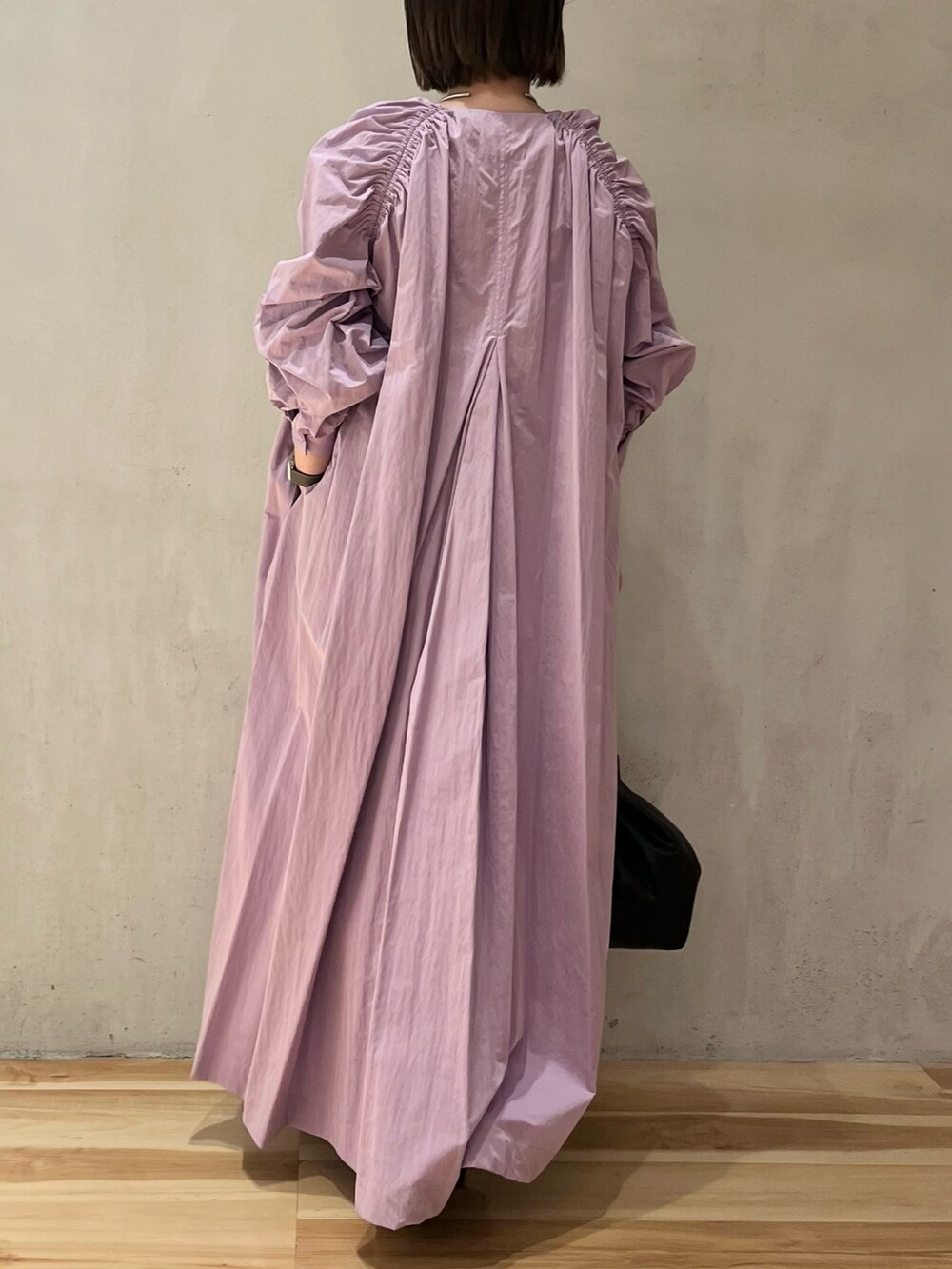 パープル系のワンピース、ブラック系のショルダーバッグを着用したレディースの春コーディネートの4枚目の写真