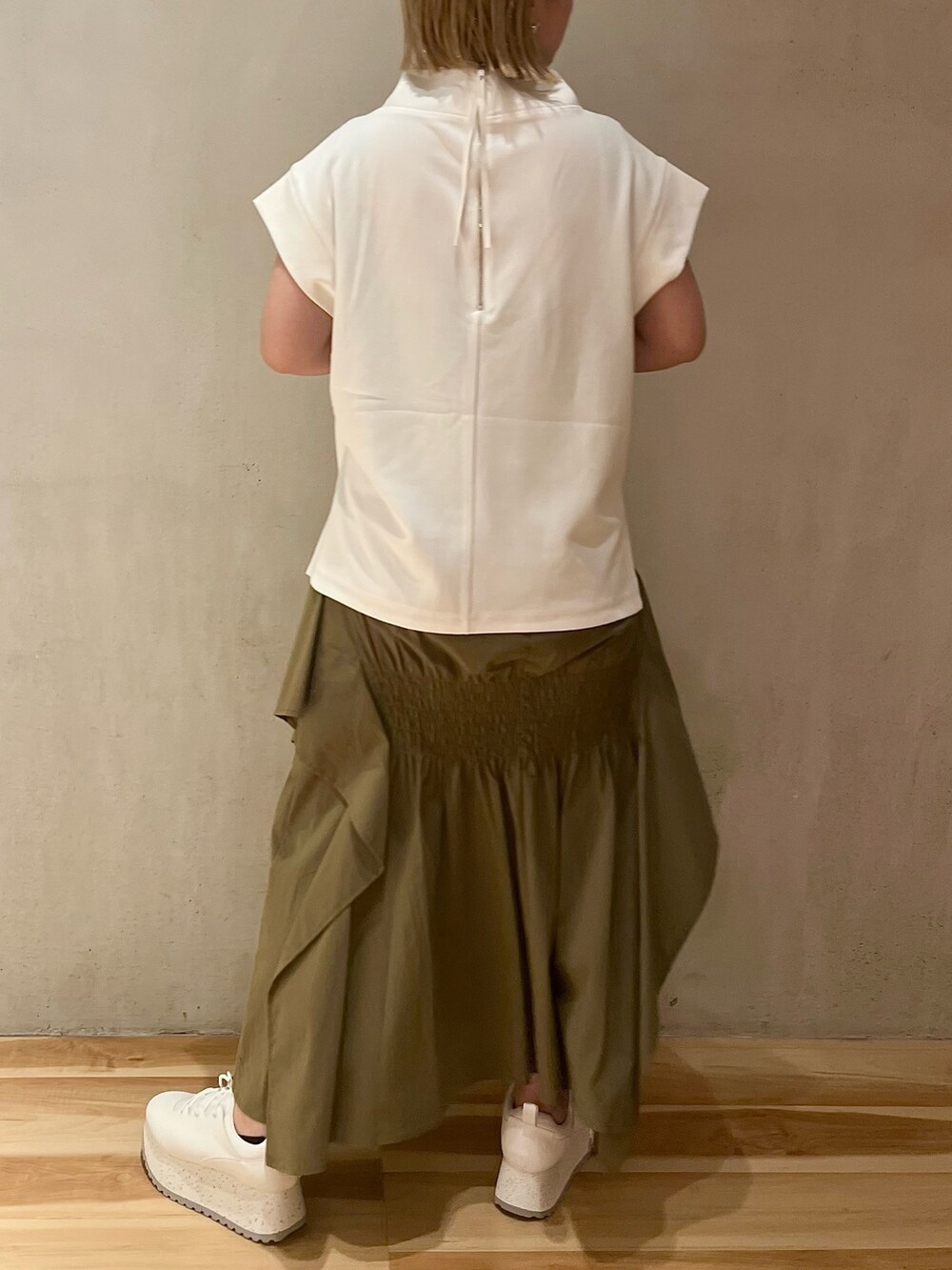 グリーン系のスカート、ホワイト系のTシャツ/カットソー、ホワイト系のスニーカーを着用したレディースの夏コーディネートの4枚目の写真