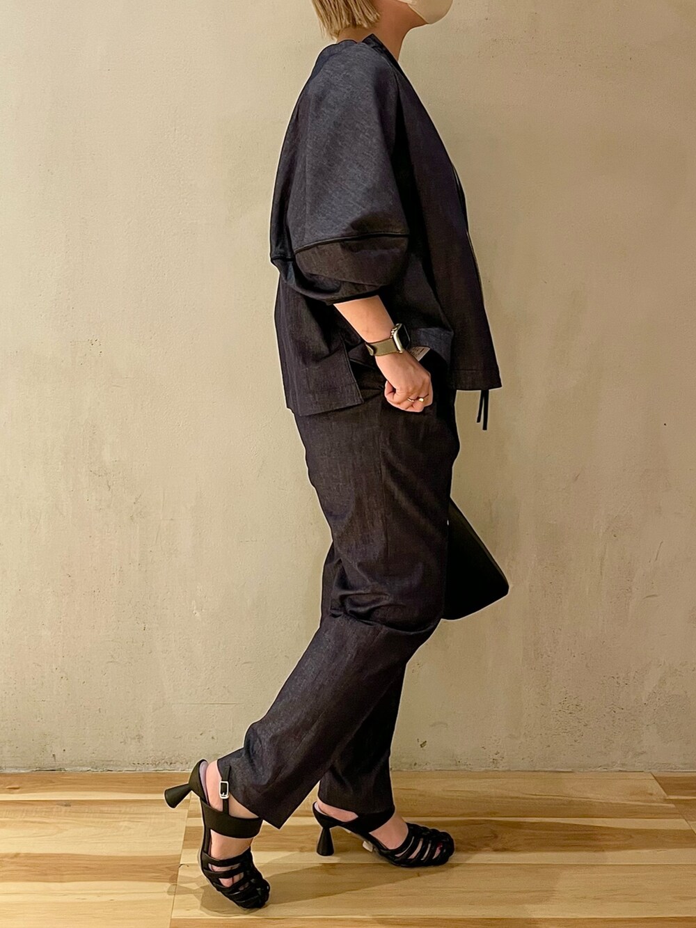 ブラック系のハンドバッグ、ブラック系のサンダル、ブルー系のブルゾンを着用したレディースの春コーディネートの2枚目の写真