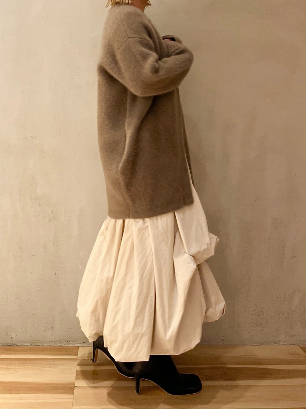 ベージュ系のノーカラージャケット、ベージュ系のワンピース、ブラック系のブーツを着用したレディースの夏コーディネートの2枚目の写真