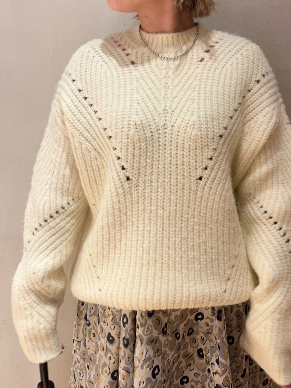 ベージュ系のスカート、ブラック系のハンドバッグ、ホワイト系のニット/セーターを着用したレディースの冬コーディネートの5枚目の写真