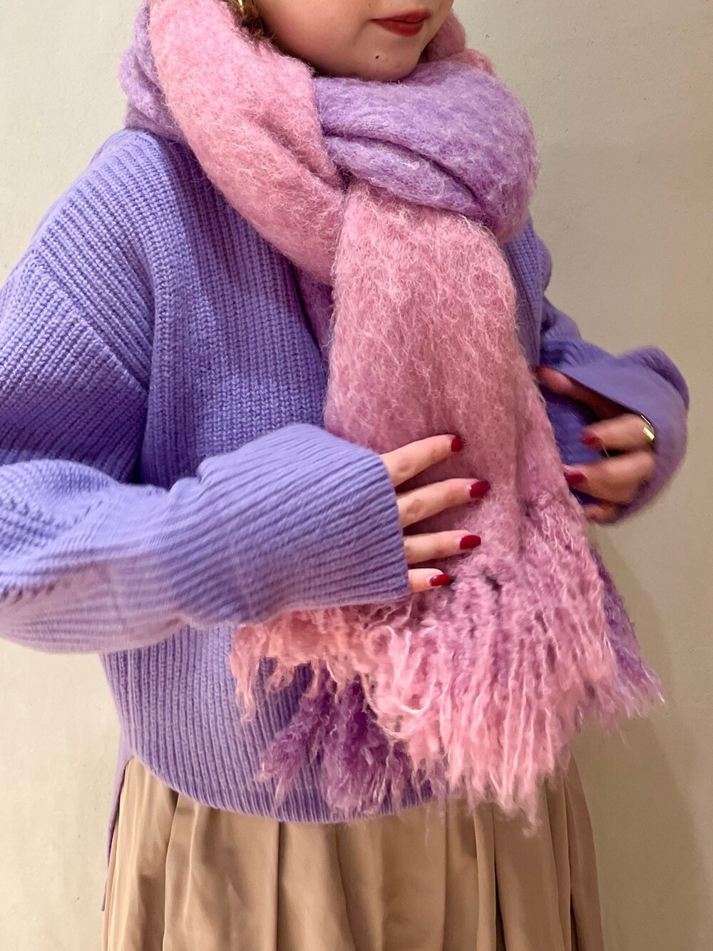 パープル系のニット/セーター、ベージュ系のスカート、パープル系のストール/ショールを着用したレディースの冬コーディネートの6枚目の写真