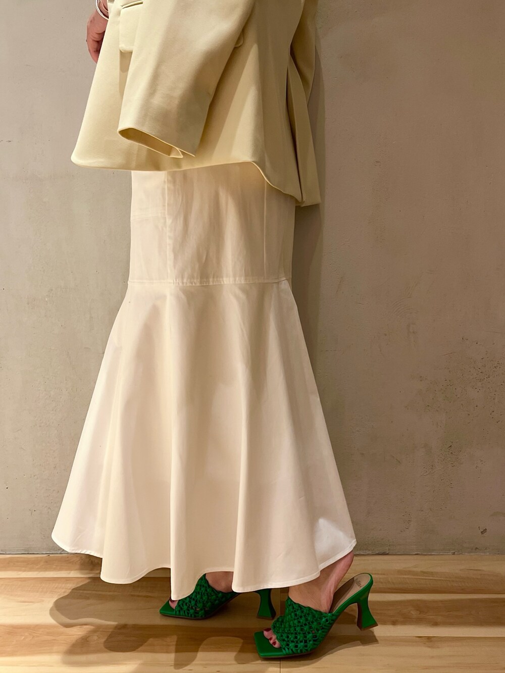 イエロー系のテーラードジャケット、ホワイト系のニット/セーター、ホワイト系のスカートを着用したレディースの冬コーディネートの8枚目の写真