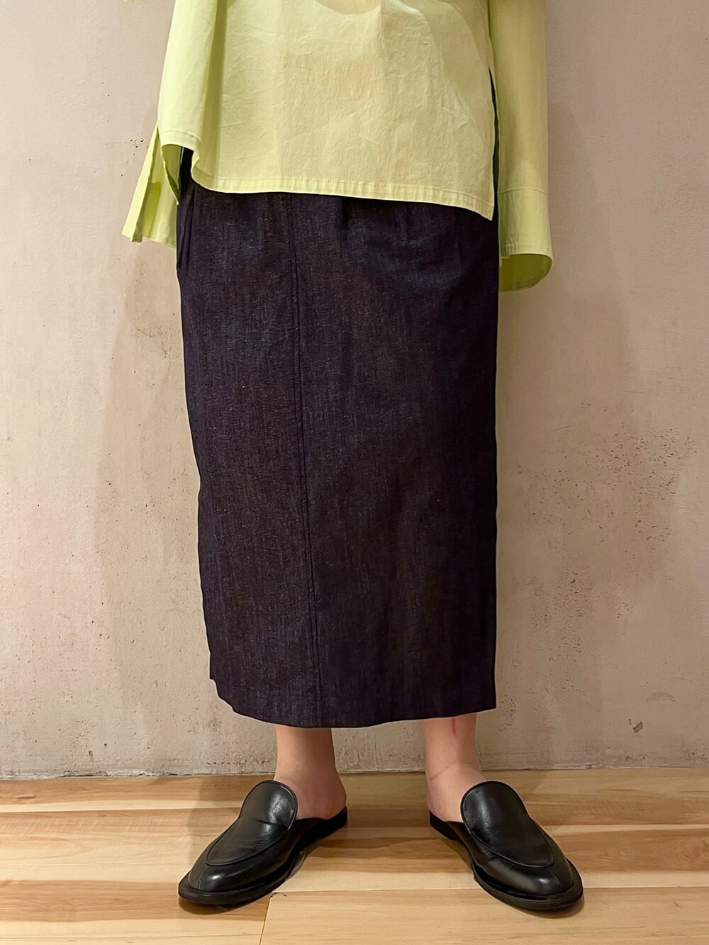 イエロー系のシャツ/ブラウス、ブルー系のスカート、シルバー系のネックレスを着用したレディースの春コーディネートの7枚目の写真