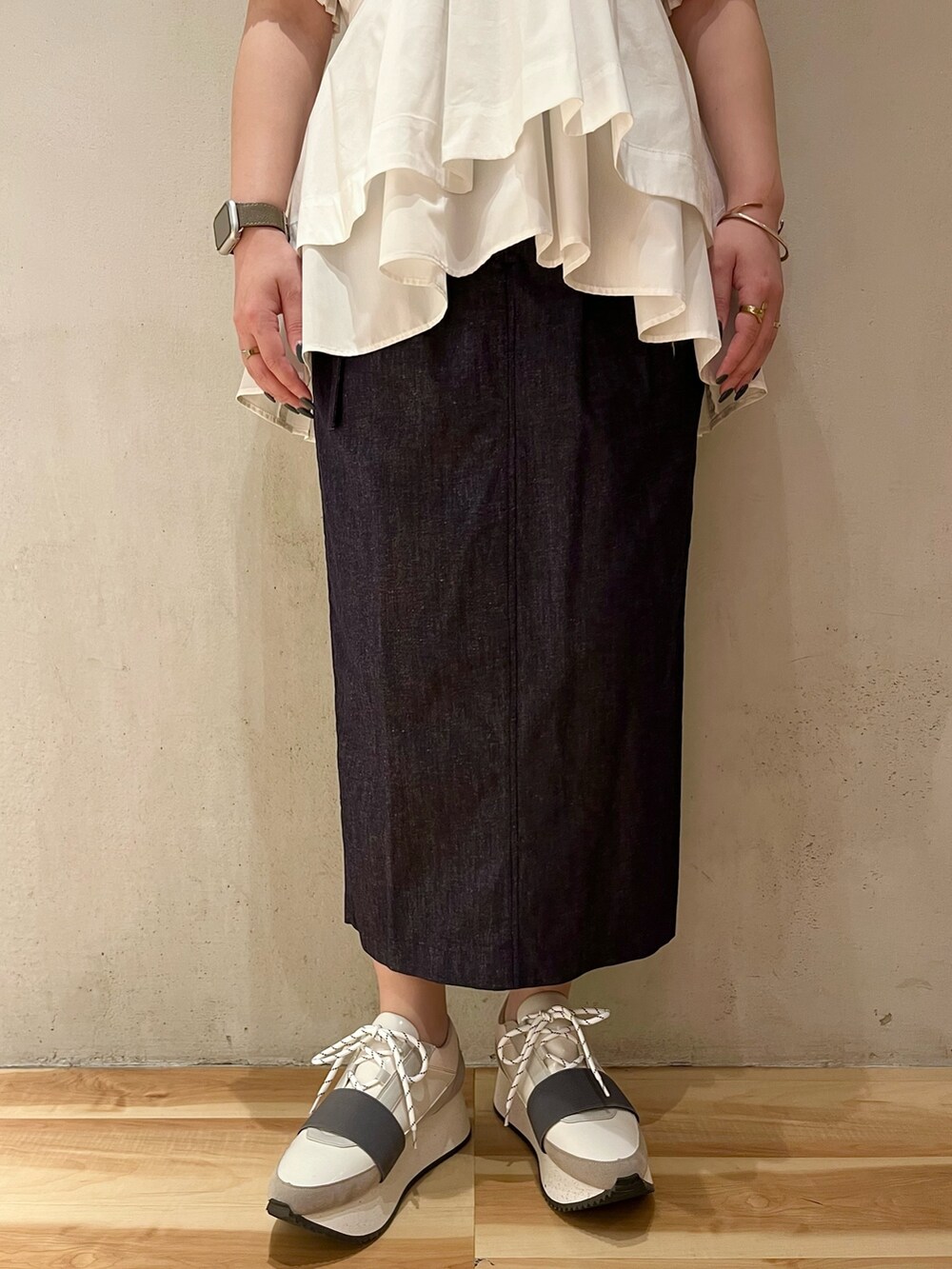 ホワイト系のシャツ/ブラウス、ブルー系のスカート、グレー系のスニーカーを着用したレディースの春コーディネートの7枚目の写真