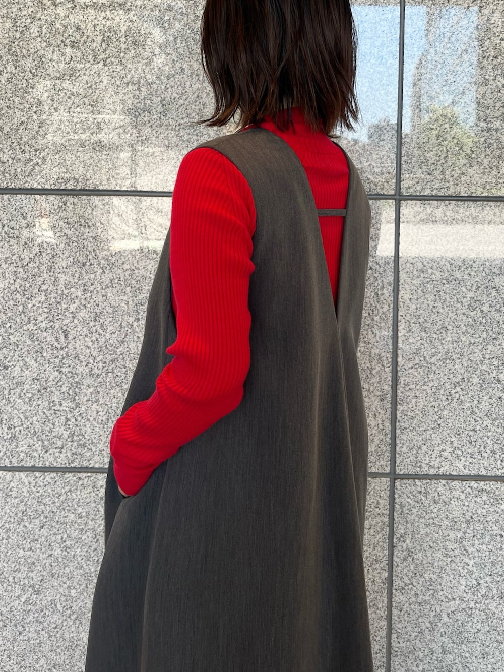 グレー系のジャンパースカート、シルバー系のブーツ、ゴールド系のハンドバッグを着用したレディースの夏コーディネートの7枚目の写真