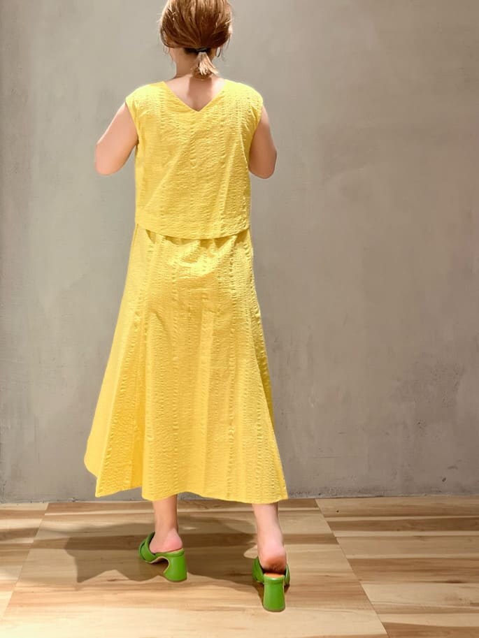 グリーン系のサンダル、イエロー系のワンピースを着用したレディースの夏コーディネートの3枚目の写真