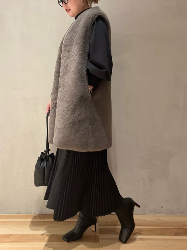 ブラック系のブーツ、ブラック系のワンピース、ブラウン系のその他アウターを着用したレディースの秋コーディネートの2枚目の写真