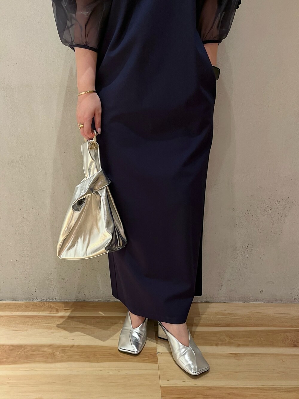 ブルー系のワンピース、シルバー系のパンプス、シルバー系のハンドバッグを着用したレディースの夏コーディネートの6枚目の写真