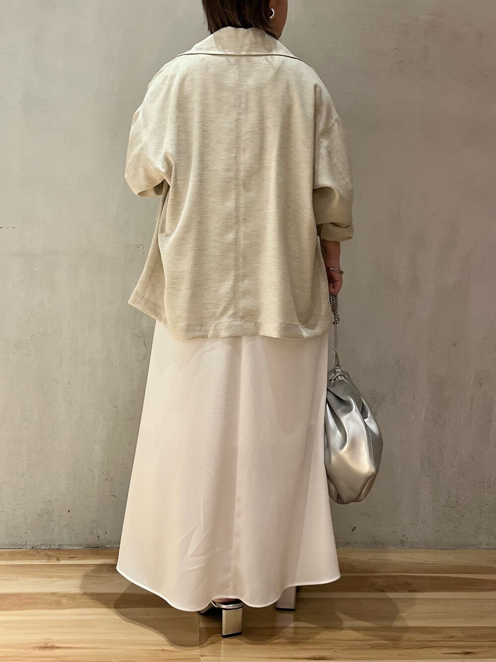 ベージュ系のテーラードジャケット、ホワイト系のワンピース、シルバー系のショルダーバッグを着用したレディースの春コーディネートの4枚目の写真