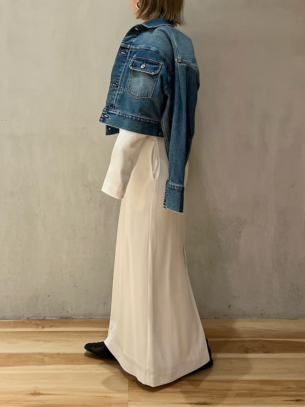 ブルー系のデニムジャケット、ホワイト系のワンピースを着用したレディースの冬コーディネートの2枚目の写真