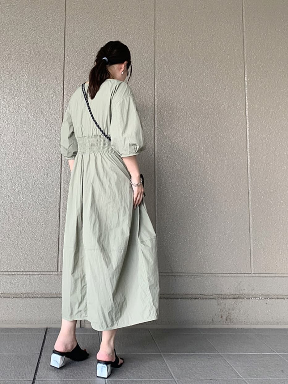 ブラック系のサンダル、グリーン系のワンピース、ブラック系のショルダーバッグを着用したレディースの夏コーディネートの2枚目の写真