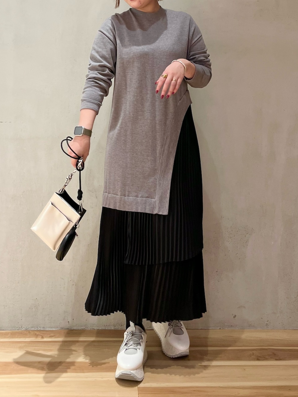 グレー系のワンピース、ホワイト系のスニーカー、ホワイト系のショルダーバッグを着用したレディースの冬コーディネートの9枚目の写真