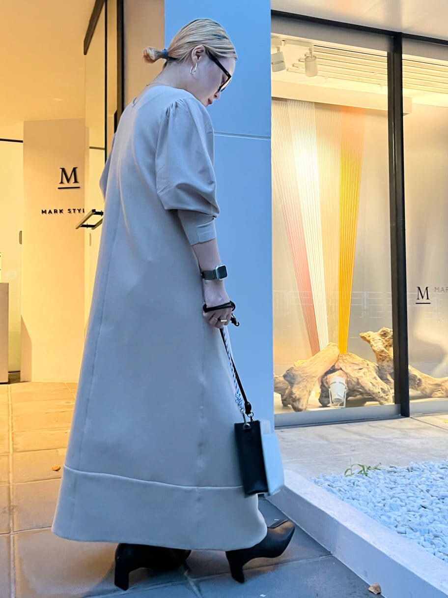 ホワイト系のショルダーバッグ、グリーン系のノーカラーコート、ベージュ系のワンピースを着用したレディースの秋コーディネートの8枚目の写真