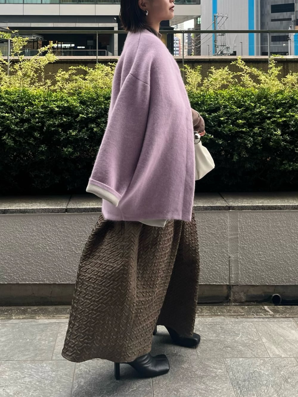 パープル系のカーディガン/ボレロ、ホワイト系のハンドバッグ、ベージュ系のワンピースを着用したレディースの夏コーディネートの2枚目の写真