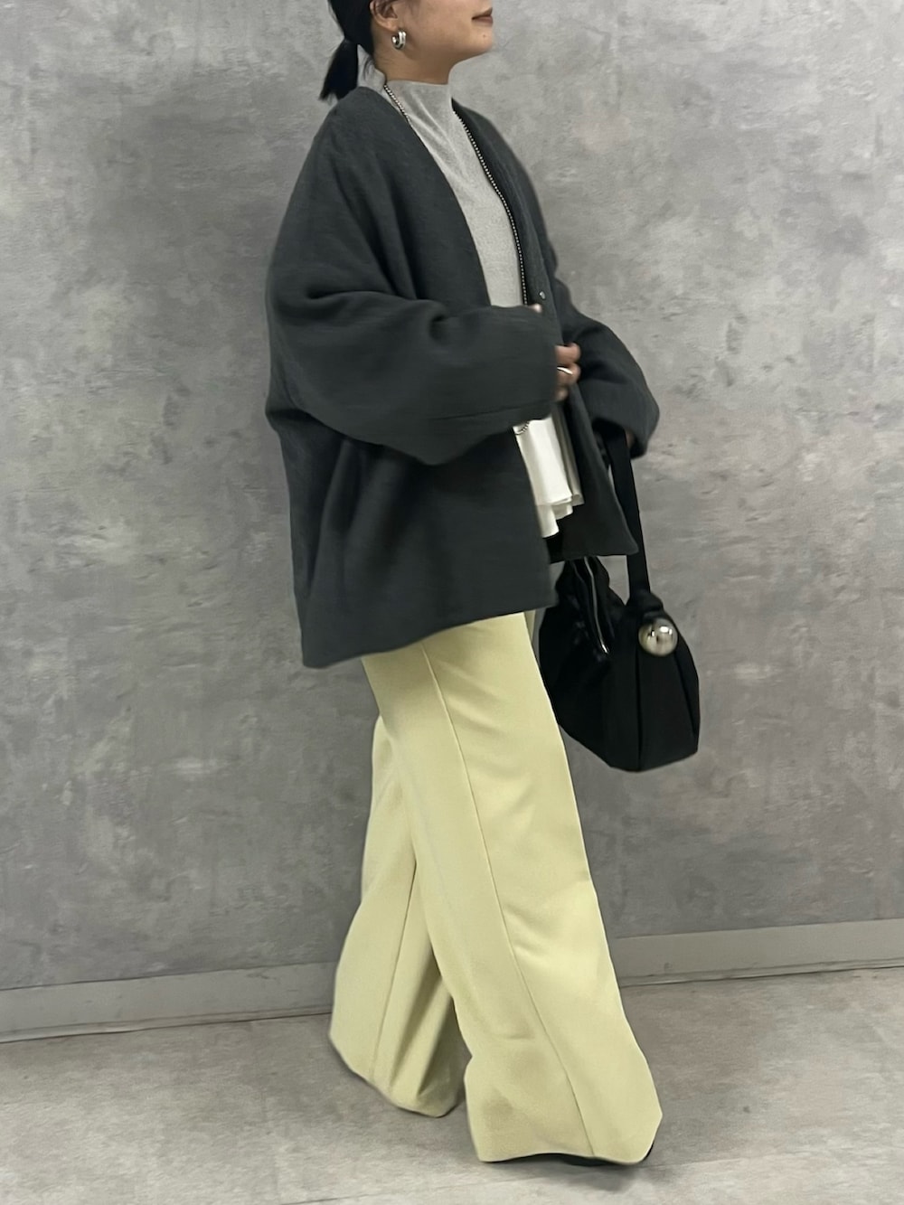 グレー系のノーカラージャケット、グレー系のニット/セーター、イエロー系のその他パンツを着用したレディースの秋コーディネートの2枚目の写真