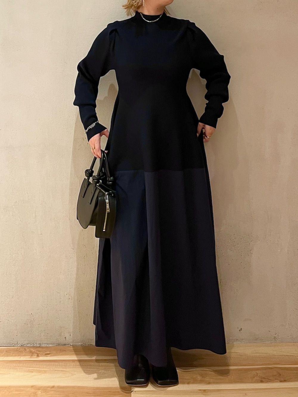 ブルー系のワンピース、ブラック系のハンドバッグ、ブラック系のブーツを着用したレディースの夏コーディネートの2枚目の写真