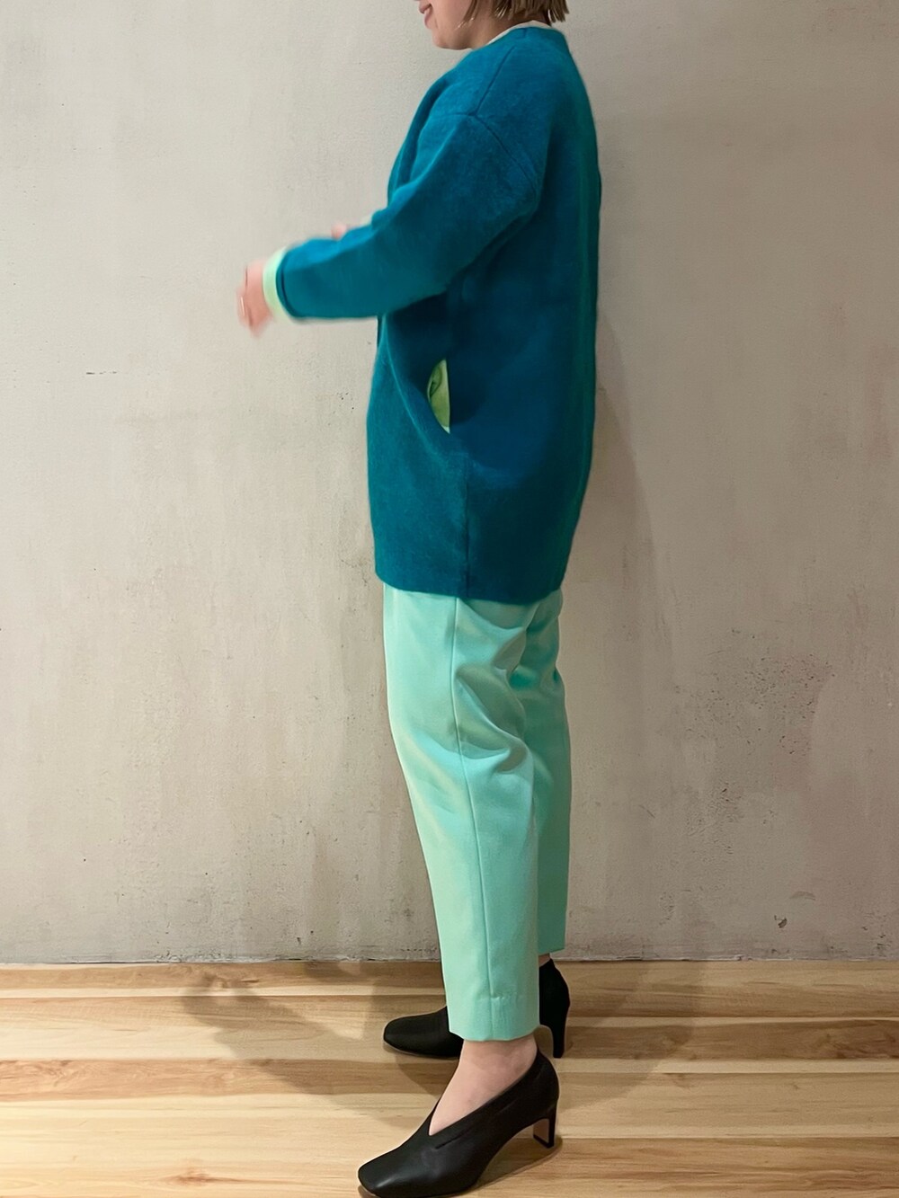 グリーン系のカーディガン/ボレロ、ホワイト系のニット/セーター、グリーン系のその他パンツを着用したレディースの冬コーディネートの2枚目の写真