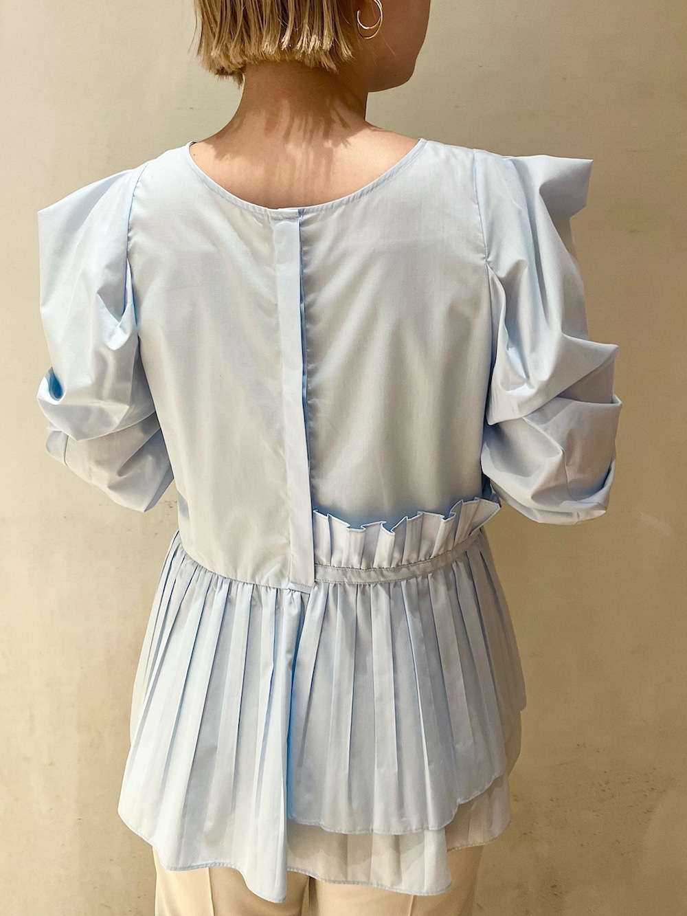 ベージュ系のノーカラーコート、ブルー系のシャツ/ブラウス、グレー系のその他パンツを着用したレディースの冬コーディネートの6枚目の写真