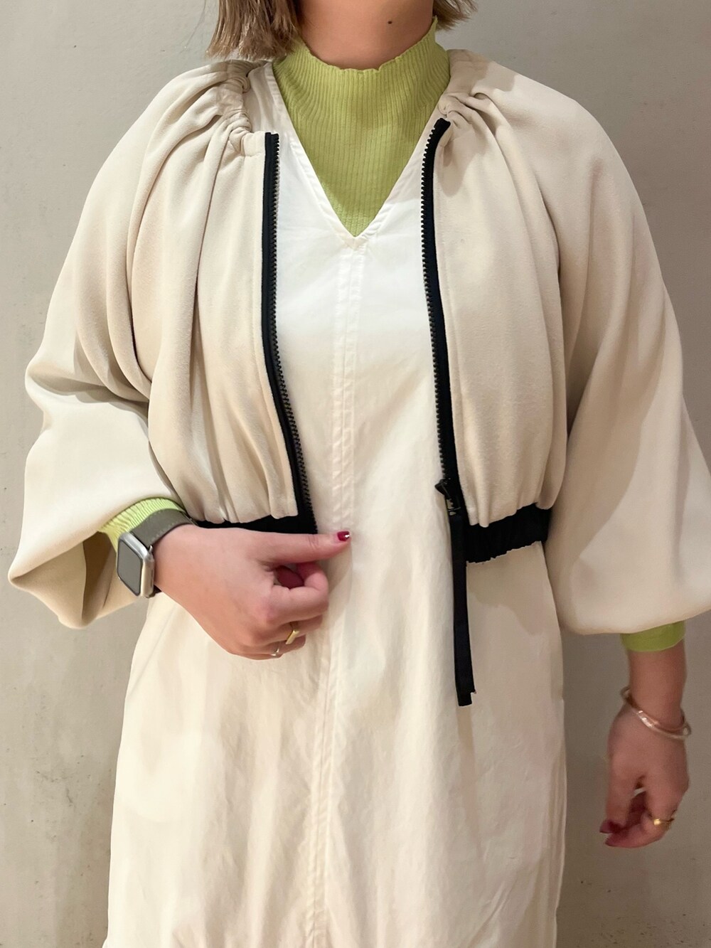 ホワイト系のワンピース、グリーン系のニット/セーターを着用したレディースの冬コーディネートの7枚目の写真