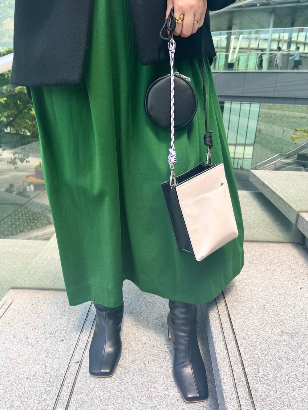グリーン系のワンピース、ホワイト系のショルダーバッグ、ブラック系のノーカラーコートを着用したレディースの夏コーディネートの9枚目の写真