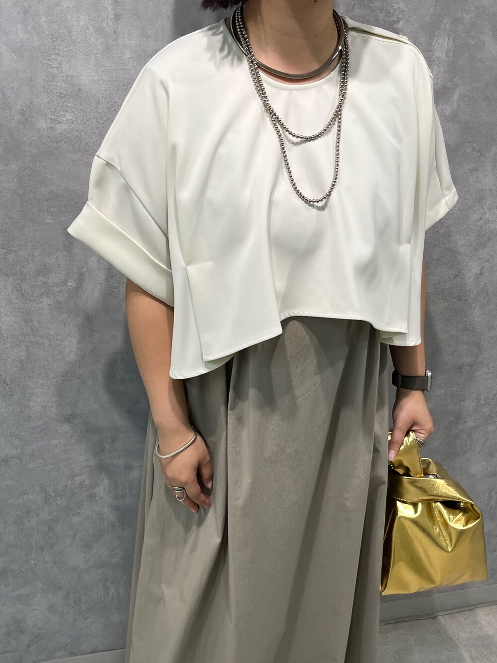 ベージュ系のワンピース、ゴールド系のハンドバッグを着用したレディースの夏コーディネートの8枚目の写真