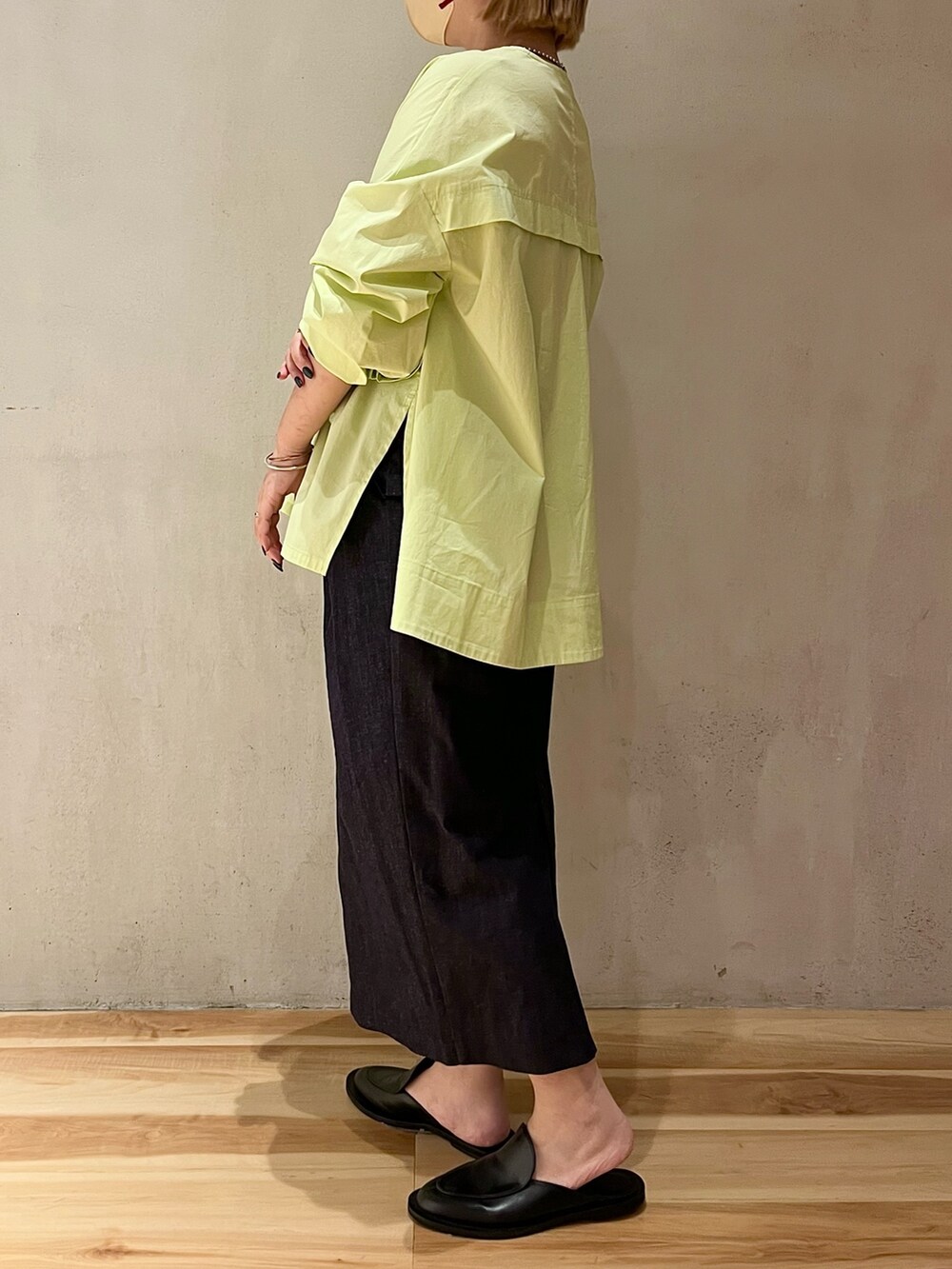 イエロー系のシャツ/ブラウス、ブルー系のスカート、シルバー系のネックレスを着用したレディースの春コーディネートの2枚目の写真