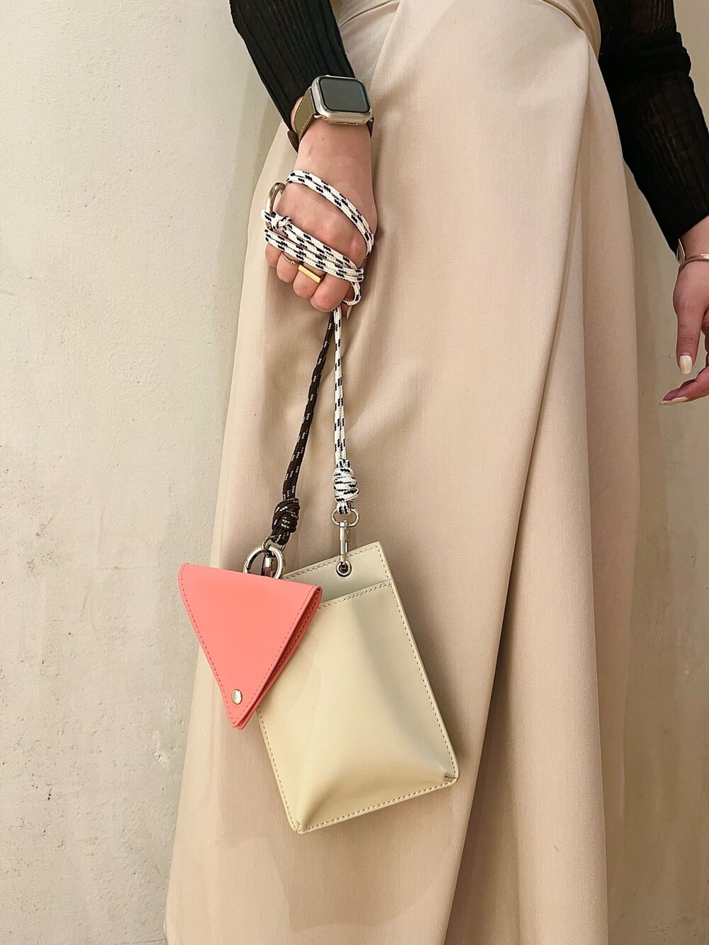 ベージュ系のショルダーバッグ、ベージュ系のジャンパースカート、ブラック系のニット/セーターを着用したレディースの冬コーディネートの7枚目の写真