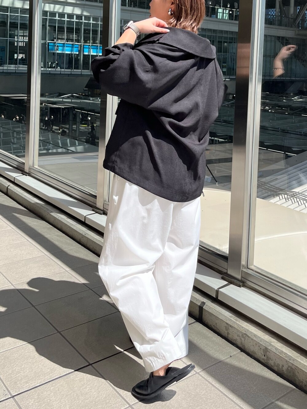 ブラック系のテーラードジャケット、ベージュ系のニット/セーター、ホワイト系のその他パンツを着用したレディースの春コーディネートの4枚目の写真