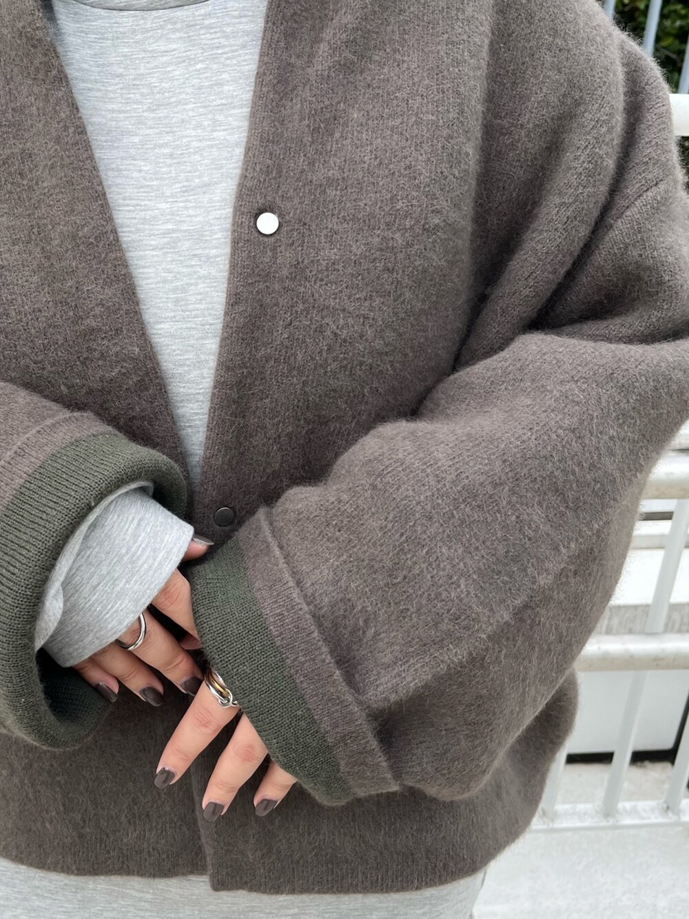 ブラウン系のカーディガン/ボレロ、グレー系のワンピース、ブラック系のブーツを着用したレディースの秋コーディネートの7枚目の写真