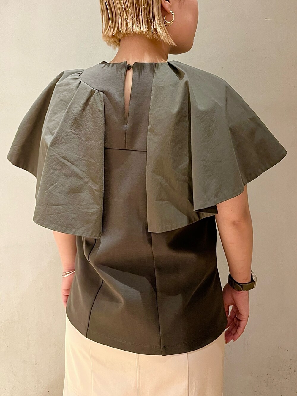 グリーン系のTシャツ/カットソー、ベージュ系のスカート、その他のサンダルを着用したレディースの春コーディネートの6枚目の写真