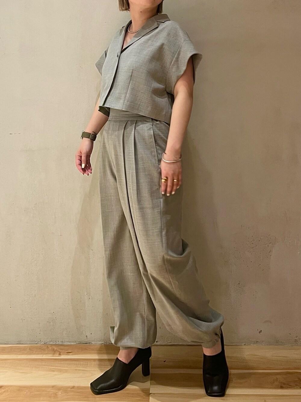 グレー系のテーラードジャケット、グレー系のスラックス、ブラック系のパンプスを着用したレディースの春コーディネートの4枚目の写真