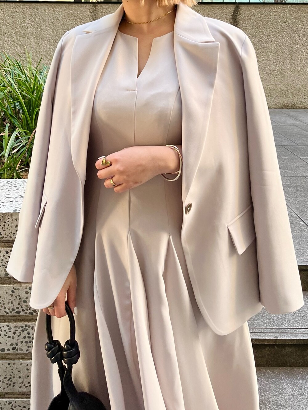 ベージュ系のワンピース、ベージュ系のテーラードジャケット、ブラック系のハンドバッグを着用したレディースの冬コーディネートの4枚目の写真