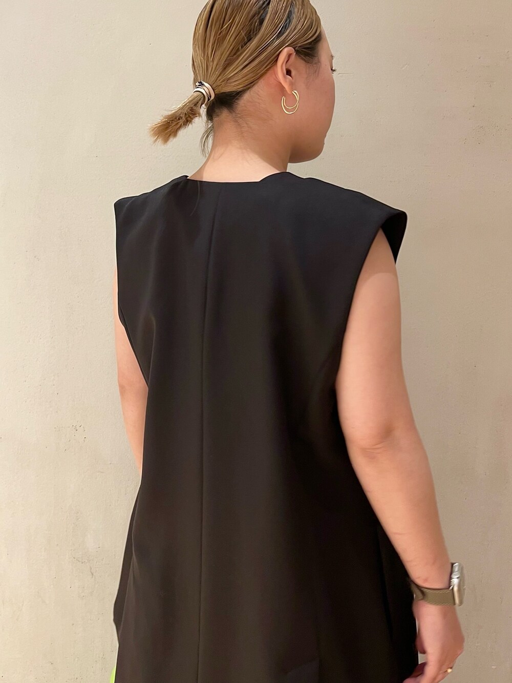 ブラック系のテーラードジャケット、ブラック系のワンピース、グリーン系のハンドバッグを着用したレディースの冬コーディネートの5枚目の写真