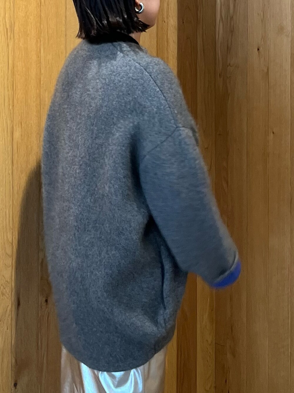 グレー系のカーディガン/ボレロ、シルバー系のスカート、ブラック系のブーツを着用したレディースの秋コーディネートの6枚目の写真