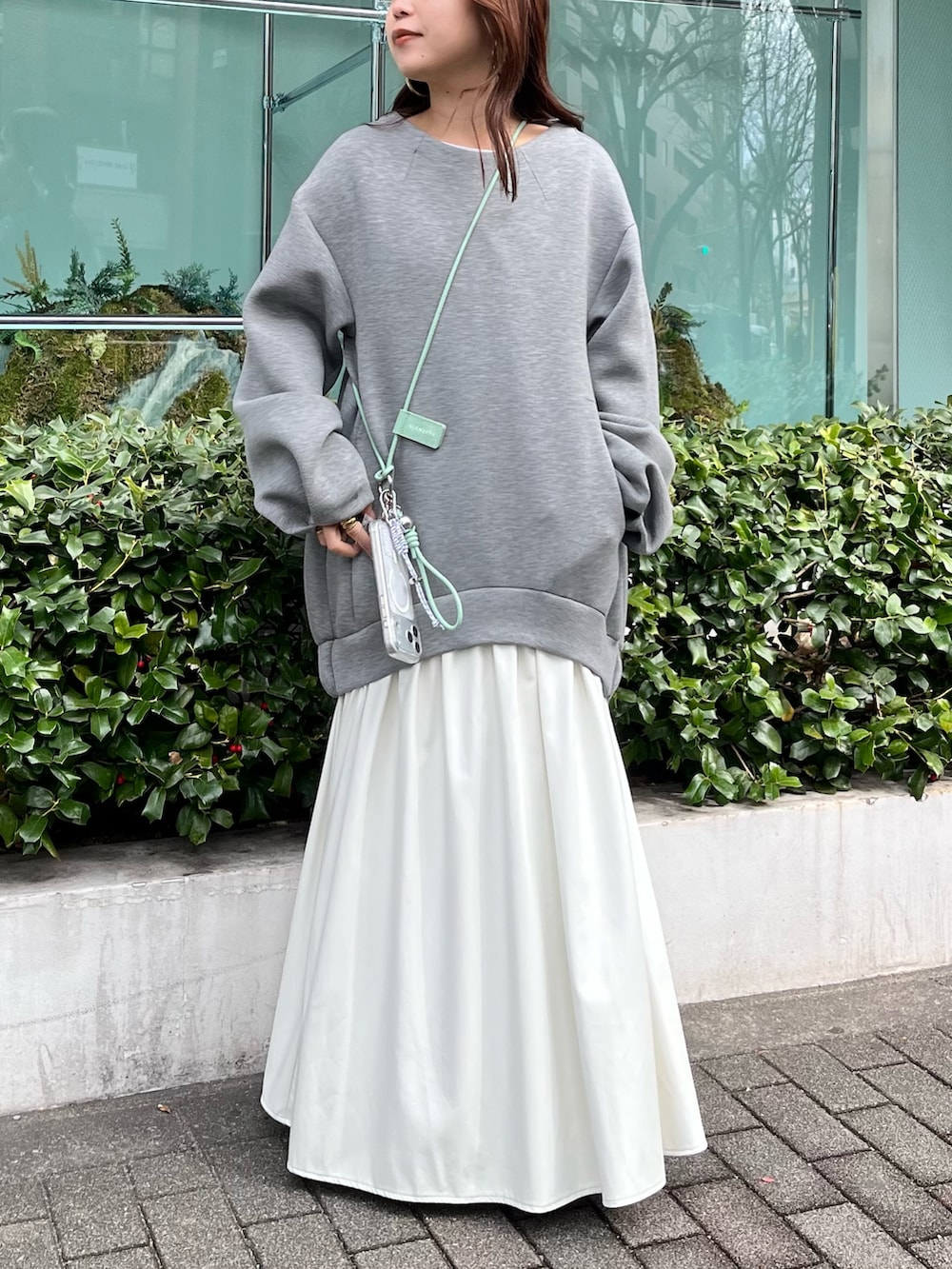 グレー系のワンピース、グリーン系のスマホケース/カバーを着用したレディースの冬コーディネートの4枚目の写真