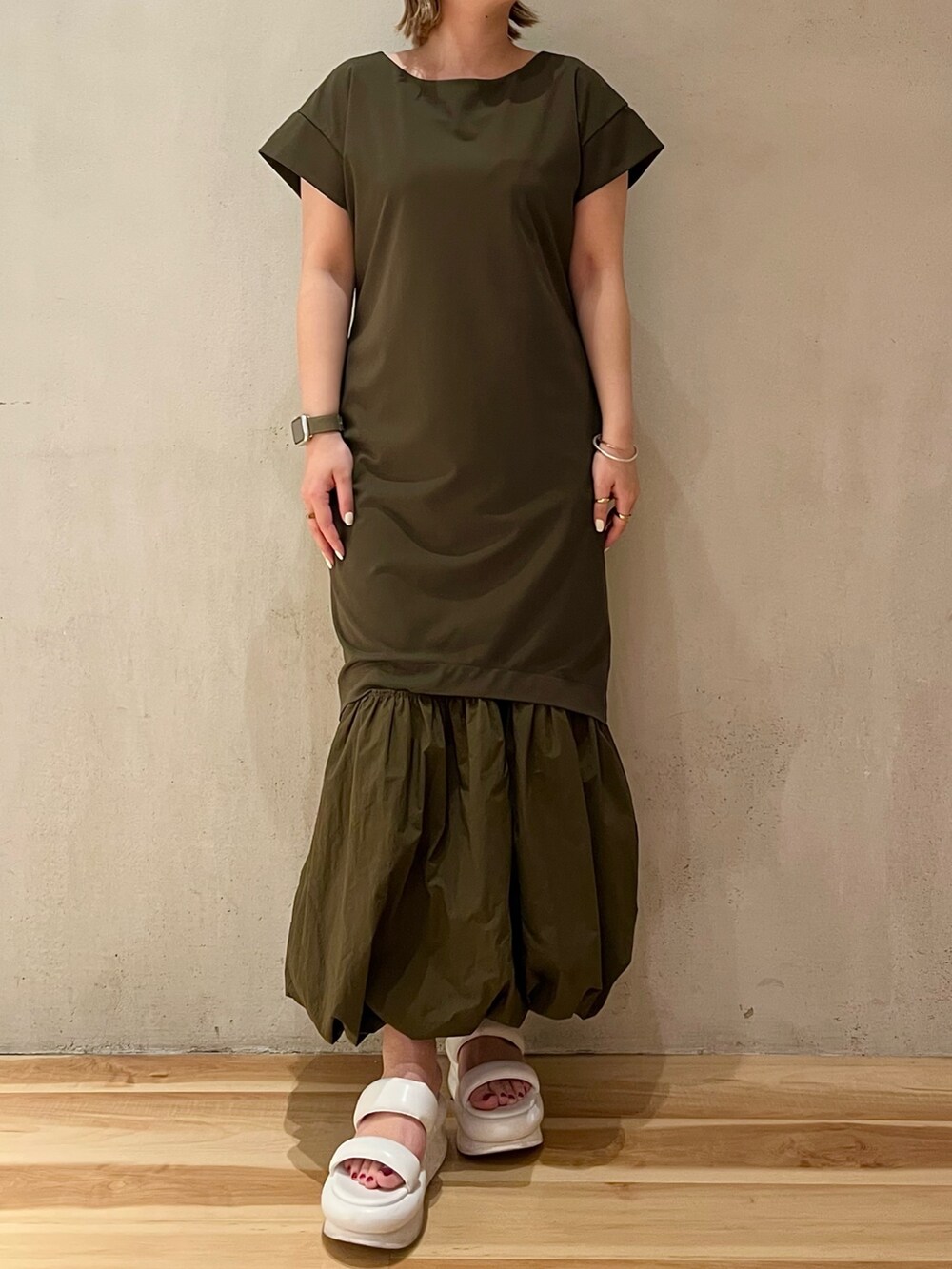 ホワイト系のサンダル、ホワイト系のブルゾン、グリーン系のワンピースを着用したレディースの冬コーディネートの6枚目の写真