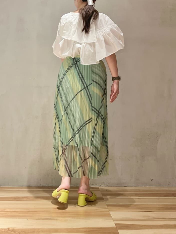 ホワイト系のシャツ/ブラウス、イエロー系のサンダル、グリーン系のスカートを着用したレディースの春コーディネートの2枚目の写真