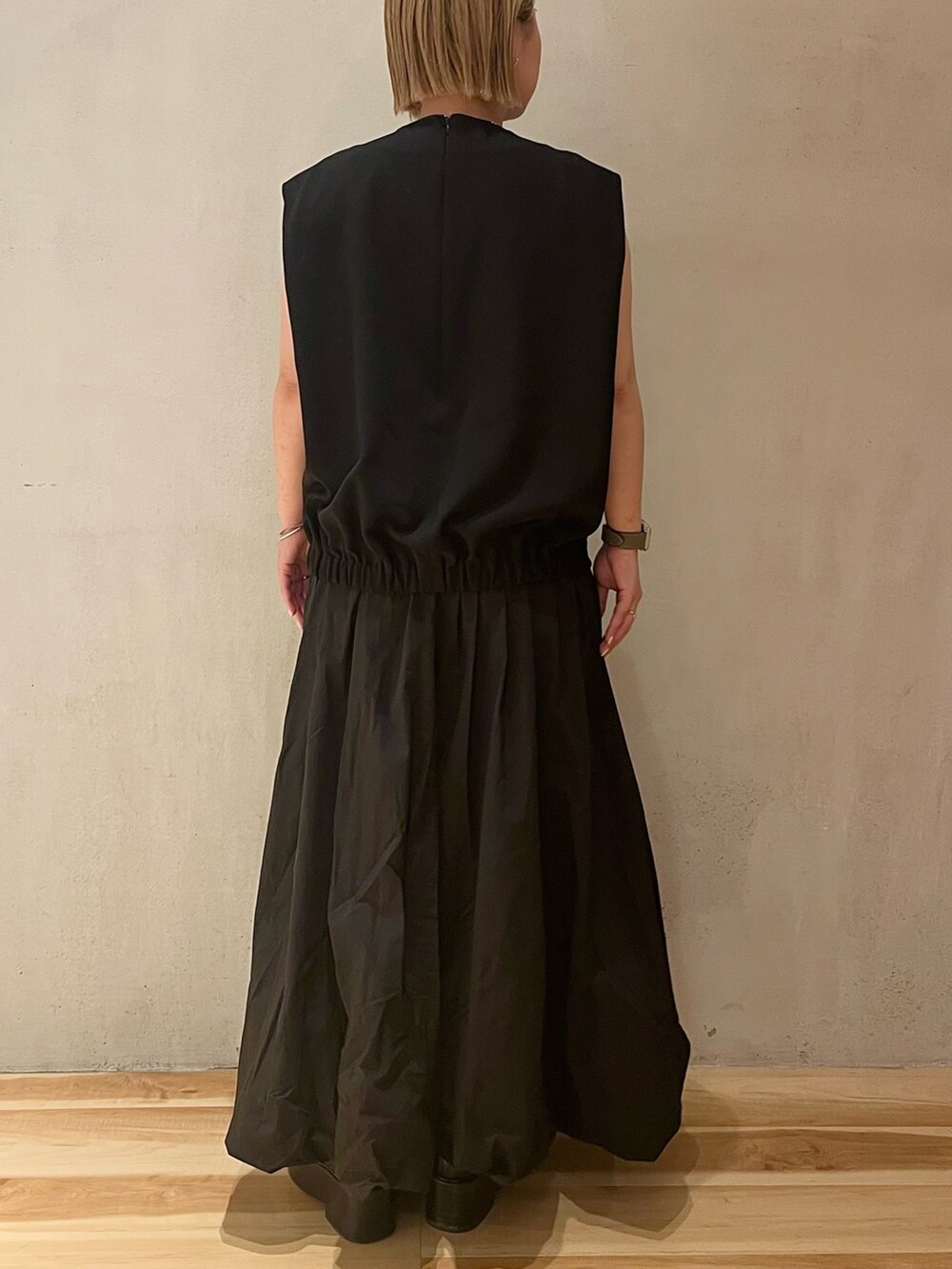 ブラック系のワンピース、ブラック系のブーツを着用したレディースの春コーディネートの3枚目の写真