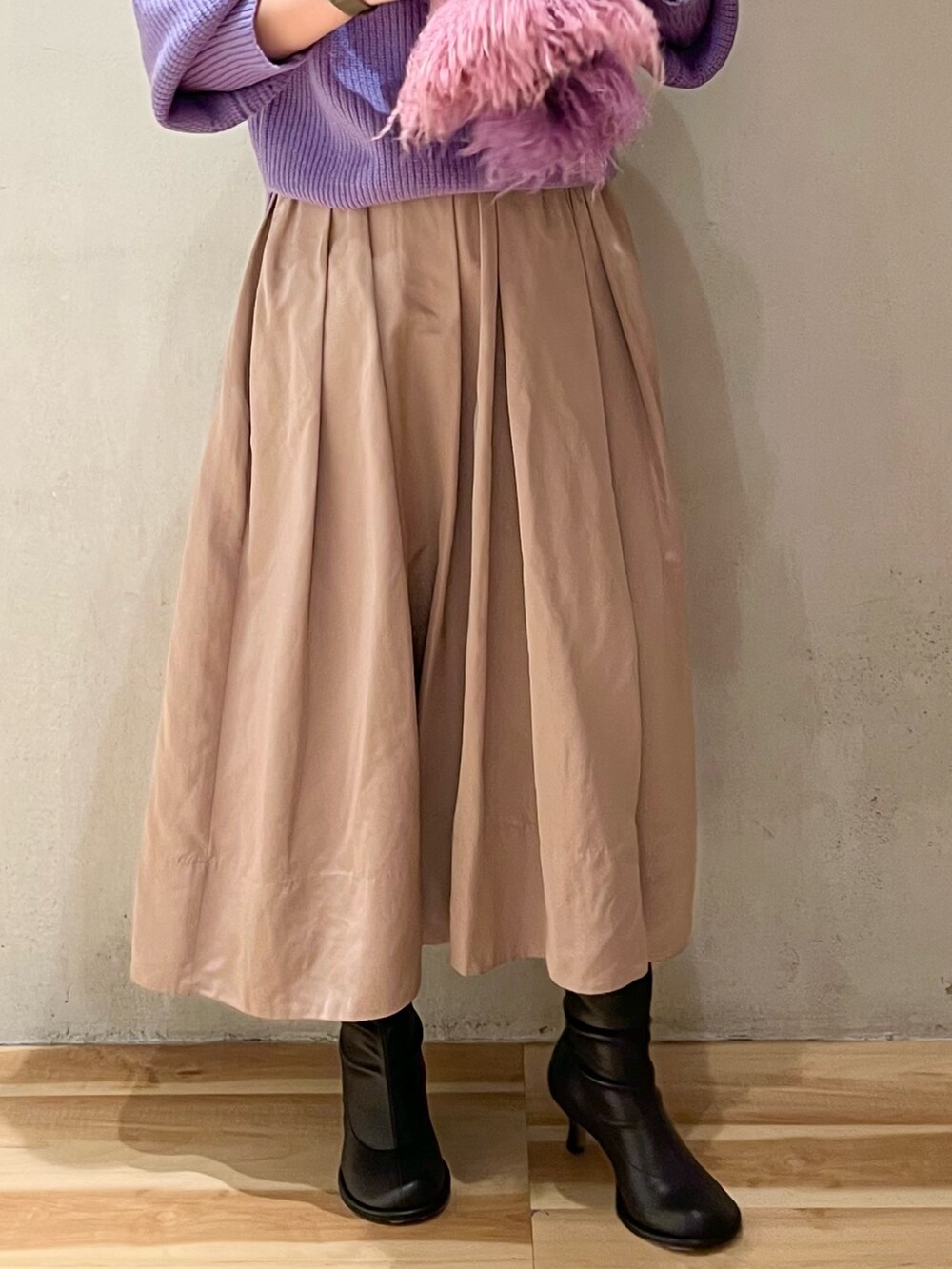 パープル系のニット/セーター、ベージュ系のスカート、パープル系のストール/ショールを着用したレディースの冬コーディネートの9枚目の写真