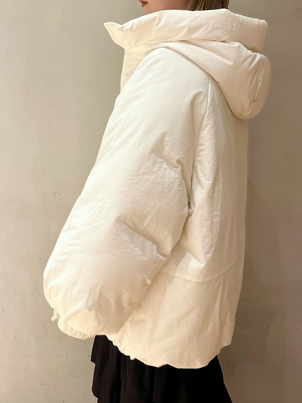 ホワイト系のダウンジャケット/コート、パープル系のニット/セーター、ブラック系のスカートを着用したレディースの夏コーディネートの6枚目の写真