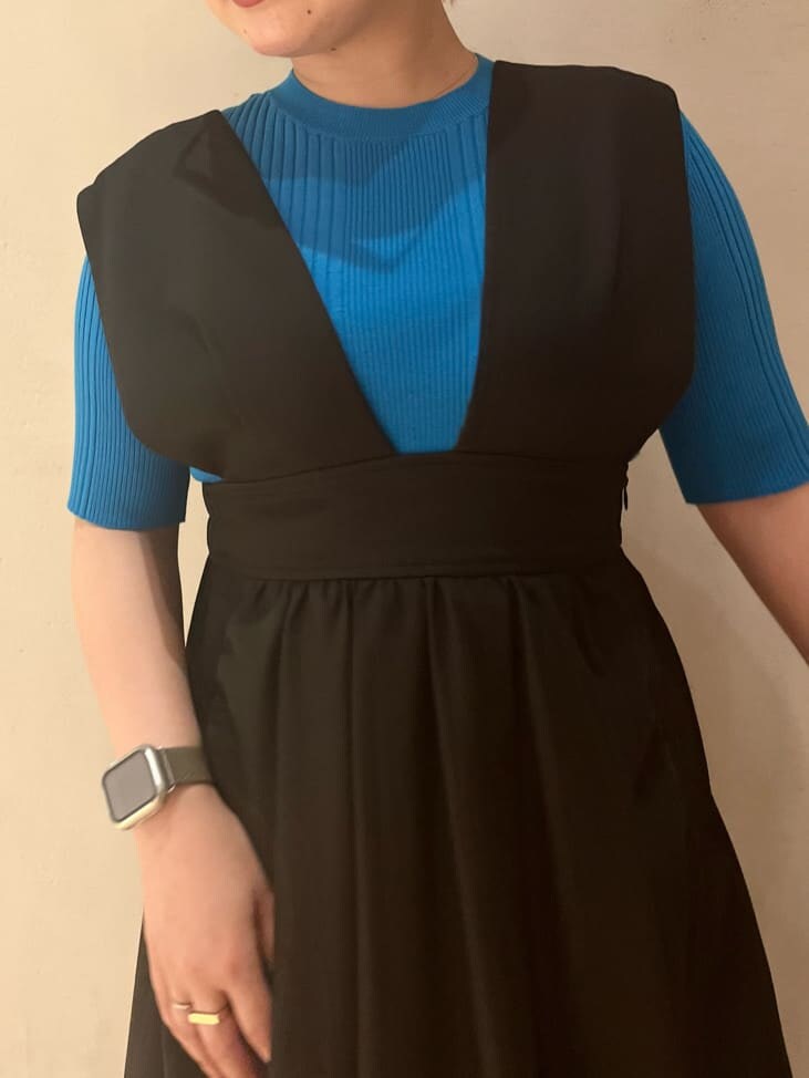 ブルー系のニット/セーター、ブラック系のジャンパースカート、ブラック系のブーツを着用したレディースの夏コーディネートの5枚目の写真