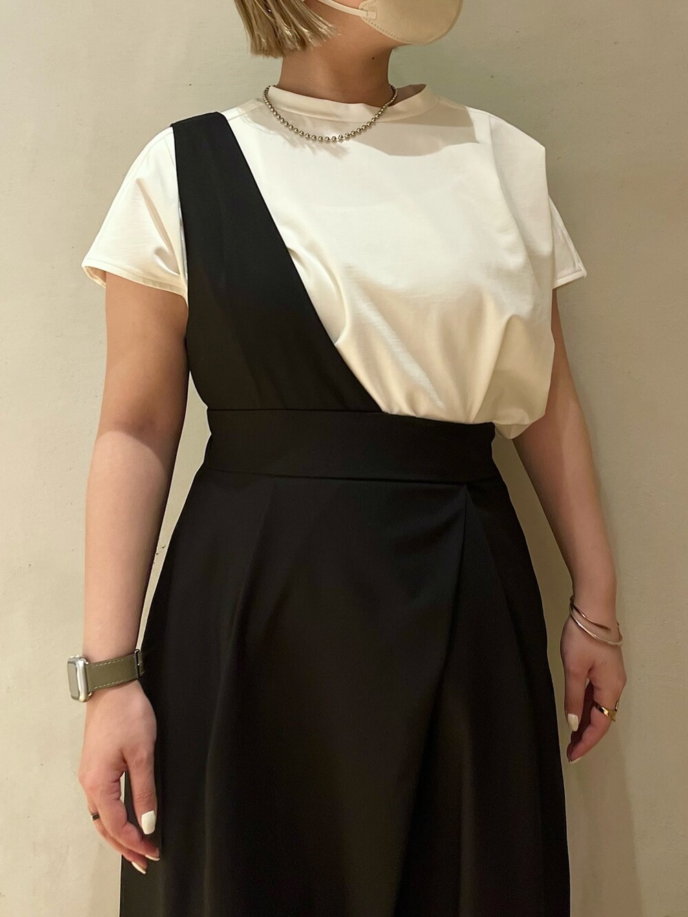 ホワイト系のTシャツ/カットソー、ブラック系のジャンパースカート、シルバー系のネックレスを着用したレディースの春コーディネートの6枚目の写真