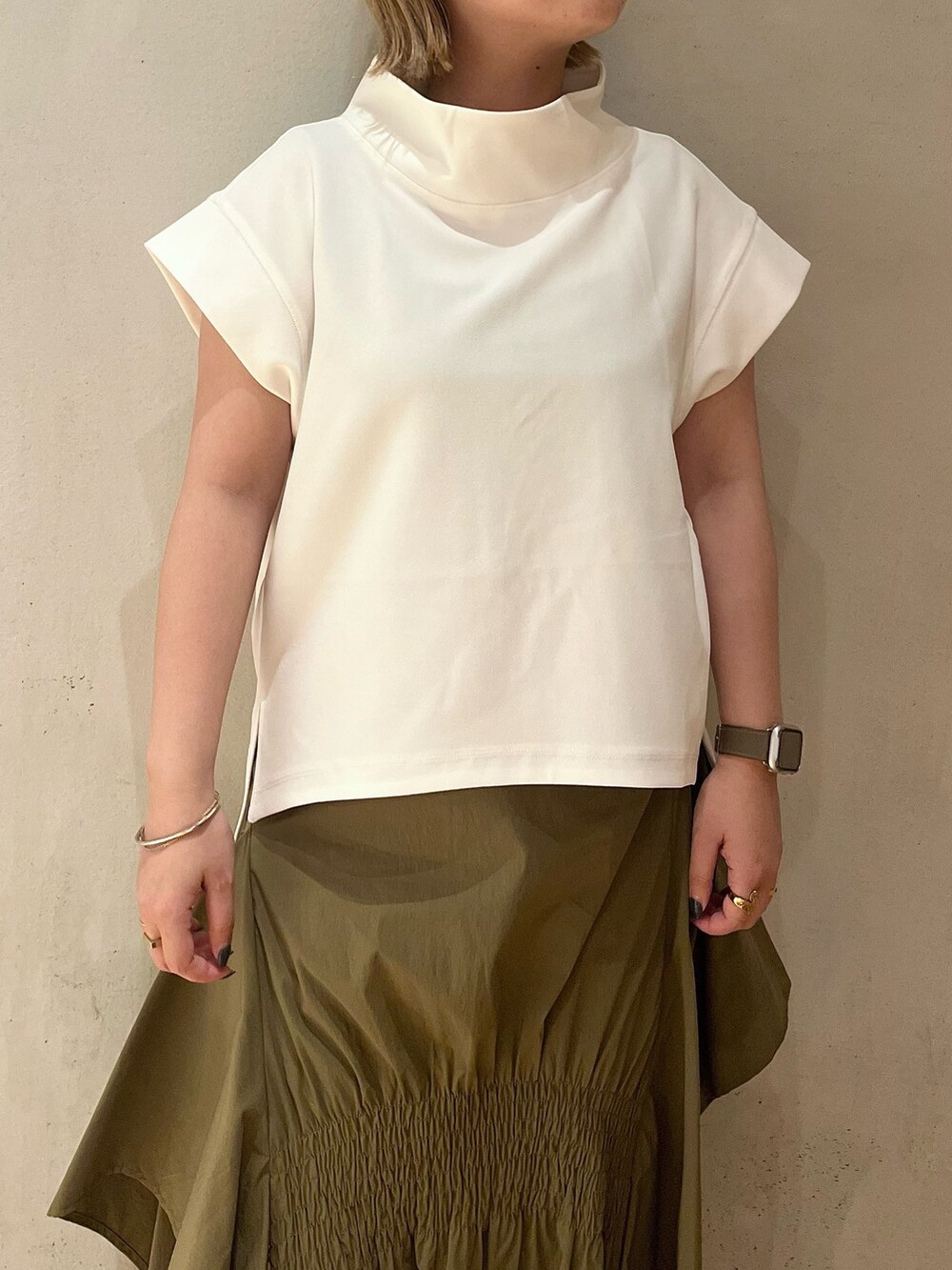 グリーン系のスカート、ホワイト系のTシャツ/カットソー、ホワイト系のスニーカーを着用したレディースの夏コーディネートの5枚目の写真