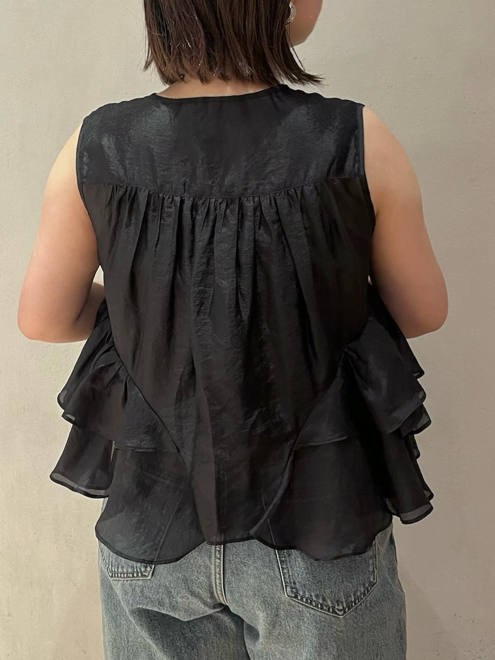 ブラック系のシャツ/ブラウス、ブルー系のデニムパンツ、ブラック系のサンダルを着用したレディースの夏コーディネートの7枚目の写真