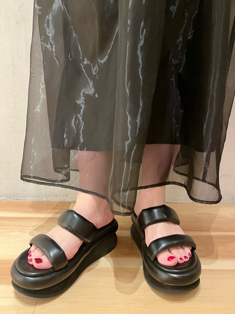 ブルー系のTシャツ/カットソー、ブラック系のスカート、ブラック系のサンダルを着用したレディースの冬コーディネートの9枚目の写真