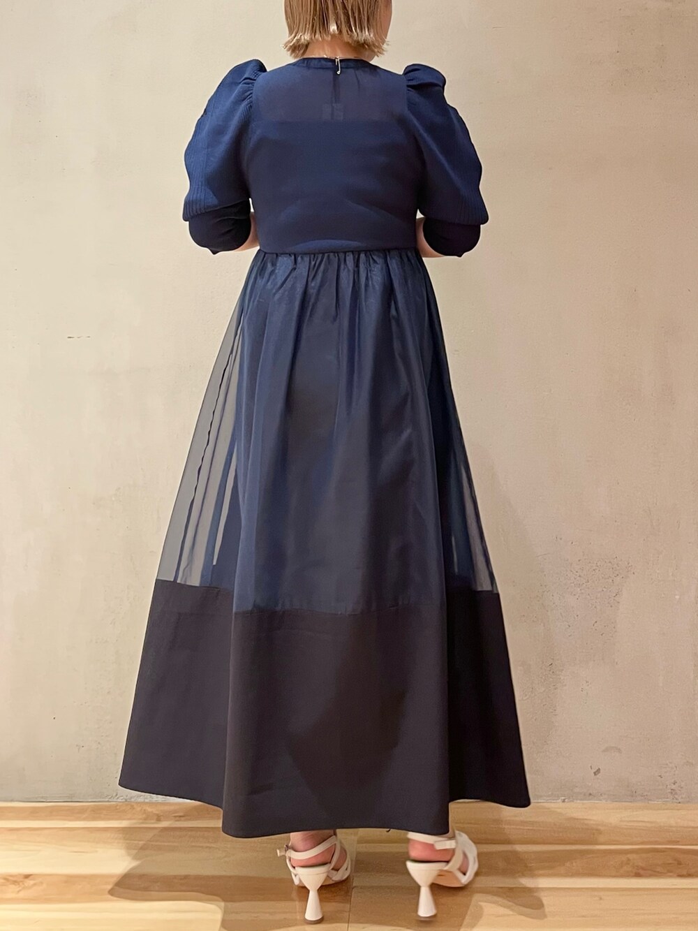 ブルー系のワンピース、ホワイト系のサンダルを着用したレディースの冬コーディネートの3枚目の写真